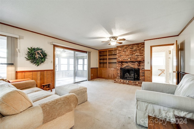 living room featuring a fireplace, built in features, and a healthy amount of sunlight