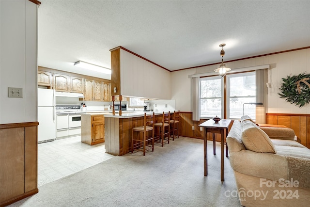 kitchen featuring kitchen peninsula, a kitchen bar, white appliances, a textured ceiling, and pendant lighting