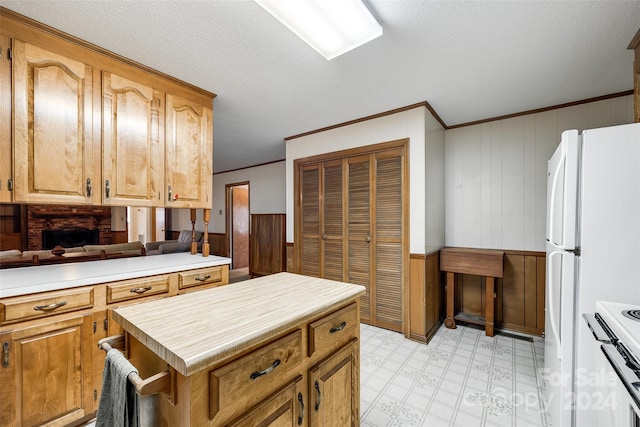 kitchen with crown molding, wooden walls, and white appliances