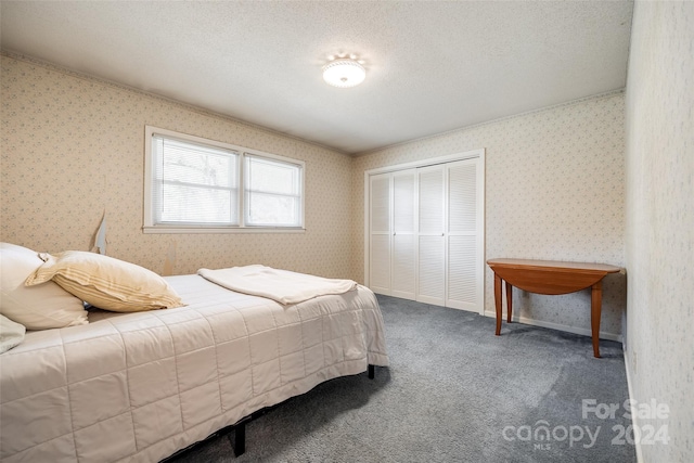 bedroom featuring a closet, carpet floors, and a textured ceiling