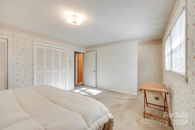 carpeted bedroom featuring a textured ceiling