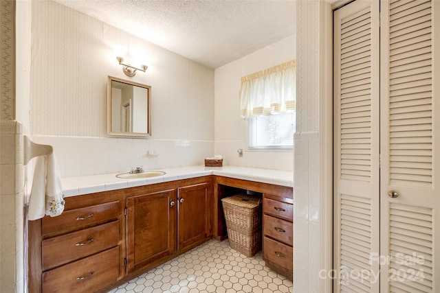 bathroom featuring tile patterned flooring, vanity, and a textured ceiling