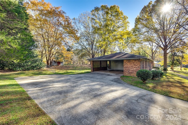 view of side of property featuring a carport and a yard