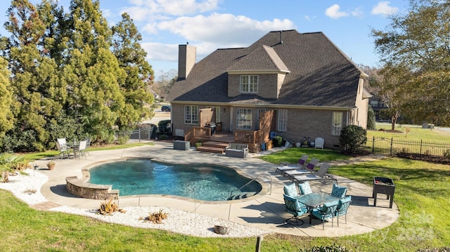 view of swimming pool with a lawn, a patio, and a wooden deck