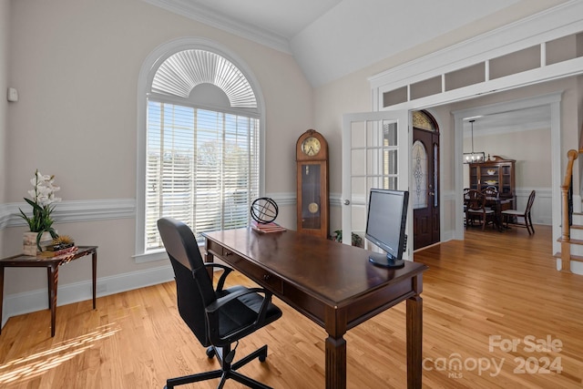 home office featuring lofted ceiling, light wood-type flooring, and ornamental molding