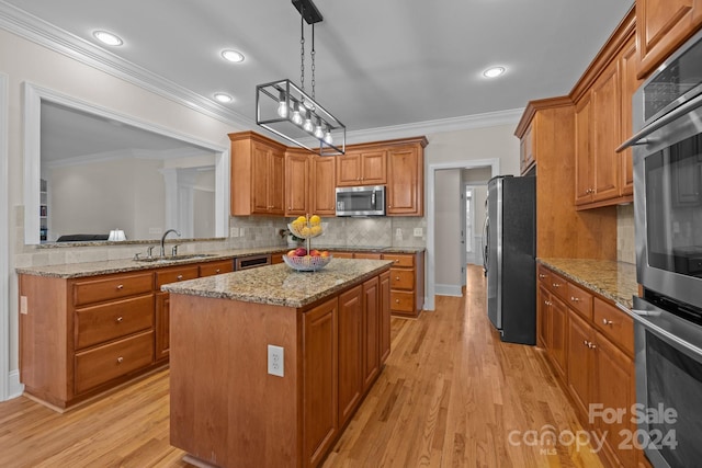 kitchen with sink, a center island, stainless steel appliances, crown molding, and light wood-type flooring