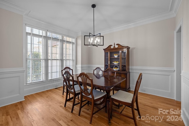 dining room featuring an inviting chandelier, ornamental molding, and light hardwood / wood-style flooring