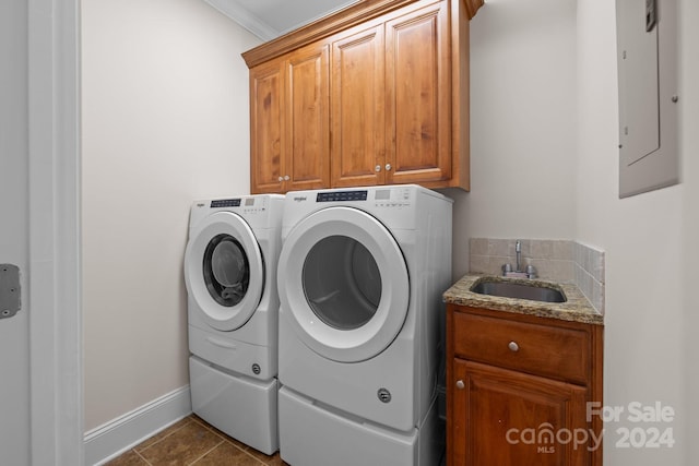 clothes washing area featuring cabinets, electric panel, crown molding, sink, and independent washer and dryer