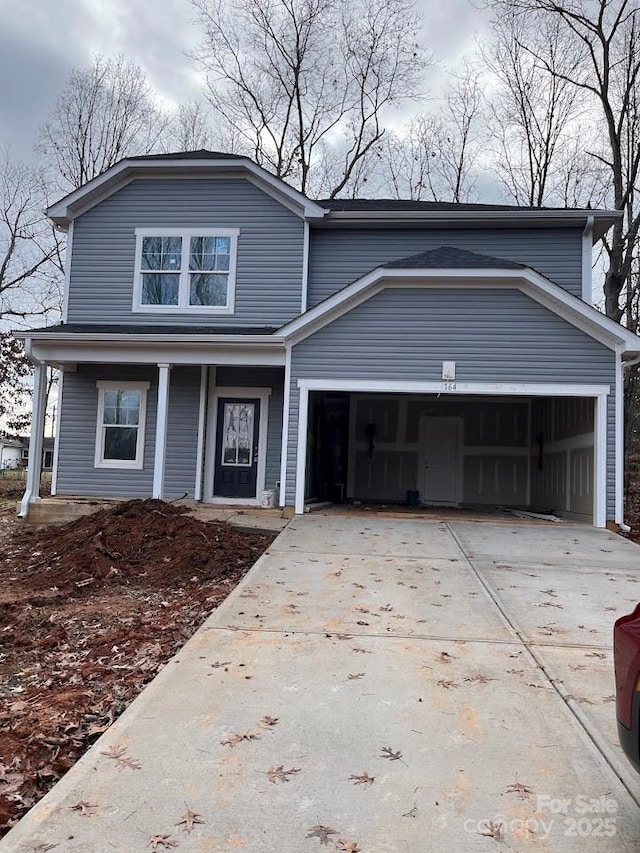 front of property featuring covered porch and a garage