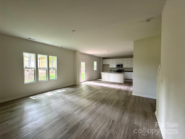 164 Wildwood Loop, Statesville, NC 28677 - unfurnished living room with dark wood-type flooring, visible vents, and baseboards