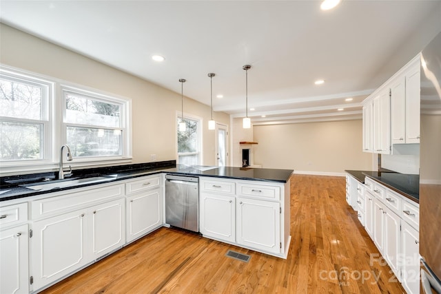 kitchen with white cabinetry, dishwasher, sink, light hardwood / wood-style flooring, and kitchen peninsula