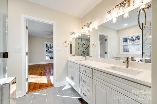 bathroom featuring a shower, wood-type flooring, vanity, and ceiling fan