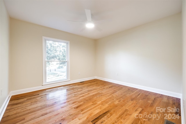 spare room with ceiling fan and wood-type flooring