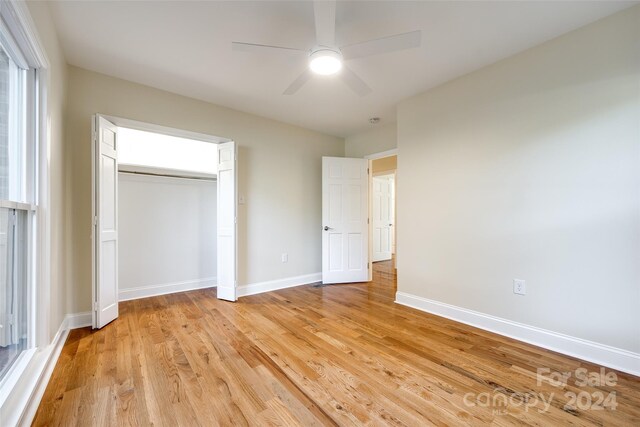 unfurnished bedroom with light wood-type flooring, a closet, and ceiling fan