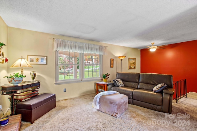 living room with carpet flooring, ceiling fan, and a textured ceiling