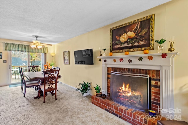 dining room featuring ceiling fan, carpet floors, a textured ceiling, and a brick fireplace