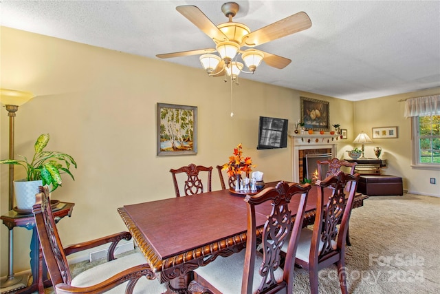 dining room with carpet flooring, ceiling fan, and a textured ceiling