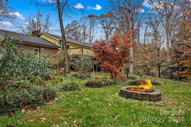 view of yard featuring a deck and an outdoor fire pit