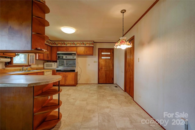 kitchen featuring decorative light fixtures, ornamental molding, sink, and black oven