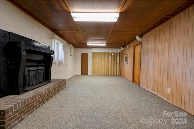 basement featuring carpet flooring, wooden walls, and wood ceiling