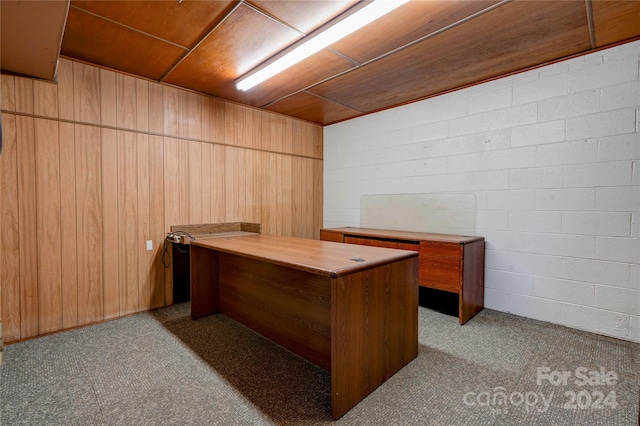 office area with light carpet and wooden walls