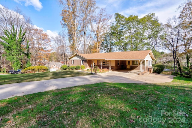 ranch-style home featuring a carport and a front lawn