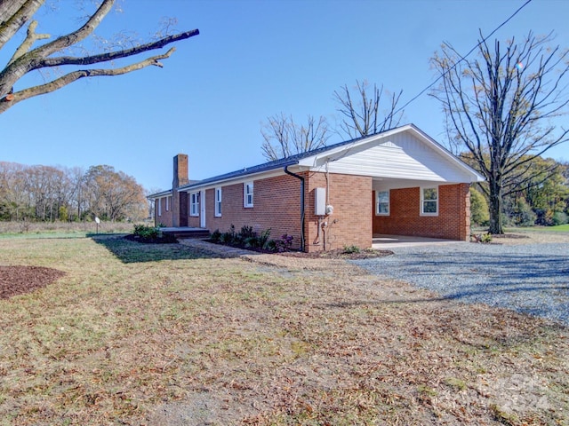 view of side of home with a yard and a carport