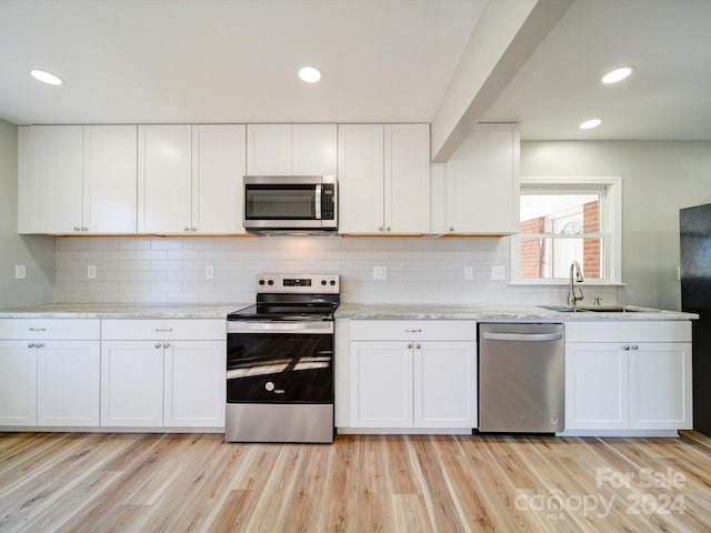 kitchen featuring white cabinets, stainless steel appliances, and light hardwood / wood-style flooring