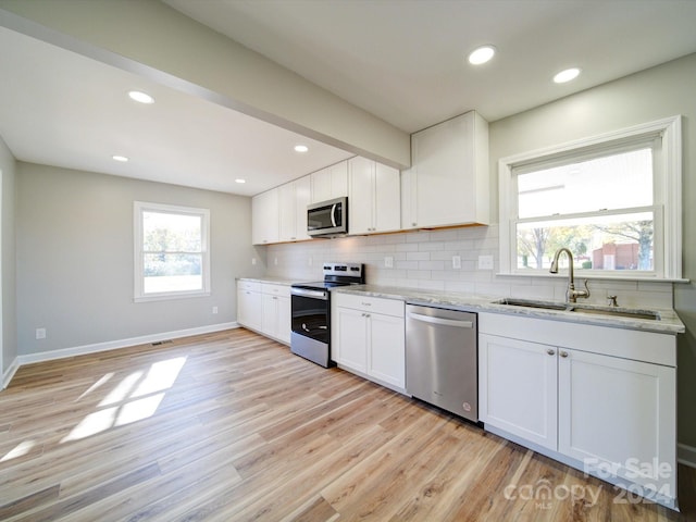 kitchen featuring white cabinets, a wealth of natural light, sink, and appliances with stainless steel finishes