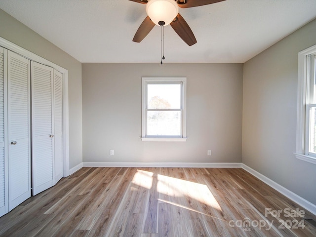 unfurnished bedroom featuring ceiling fan, a closet, and light hardwood / wood-style floors