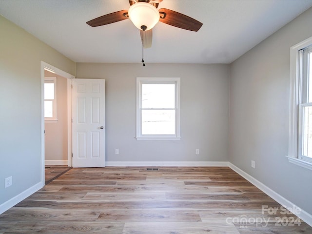 spare room with ceiling fan, plenty of natural light, and light hardwood / wood-style flooring