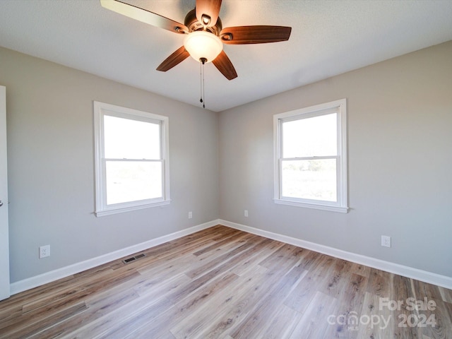 unfurnished room with ceiling fan, a healthy amount of sunlight, and light hardwood / wood-style flooring