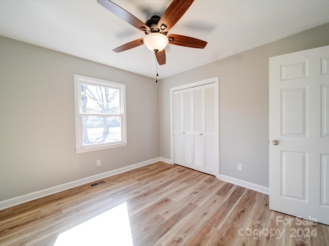 unfurnished bedroom featuring ceiling fan, a closet, and light hardwood / wood-style floors