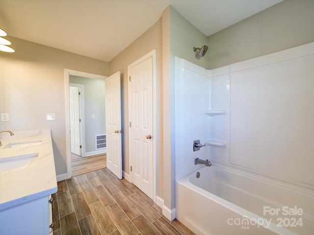 bathroom with vanity, washtub / shower combination, and hardwood / wood-style flooring