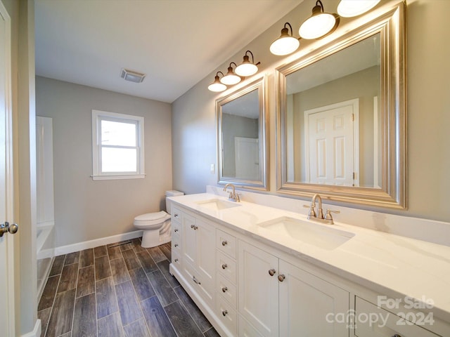 bathroom with hardwood / wood-style floors, vanity, and toilet