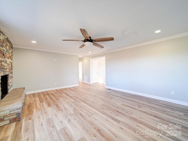 unfurnished living room with a stone fireplace, light hardwood / wood-style flooring, and ornamental molding