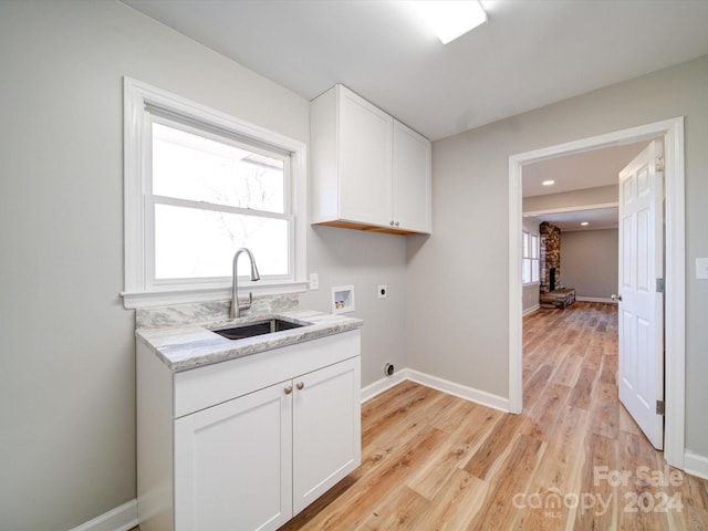 clothes washing area with cabinets, sink, hookup for a washing machine, light wood-type flooring, and hookup for an electric dryer