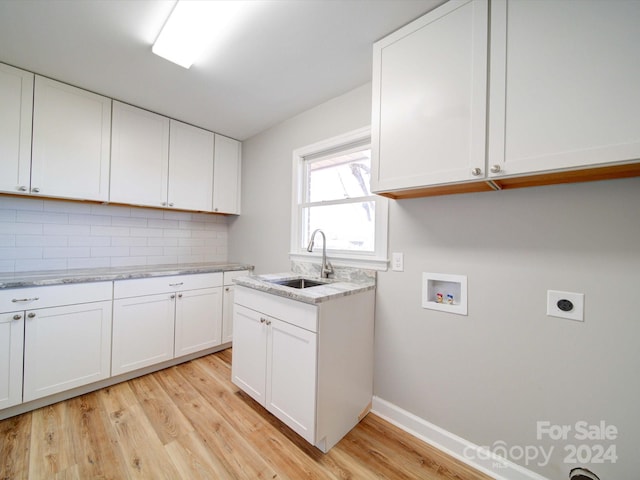 kitchen with sink, light hardwood / wood-style flooring, light stone countertops, tasteful backsplash, and white cabinetry