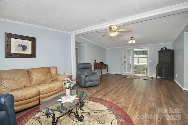 living room with crown molding, a textured ceiling, baseboards, and wood finished floors