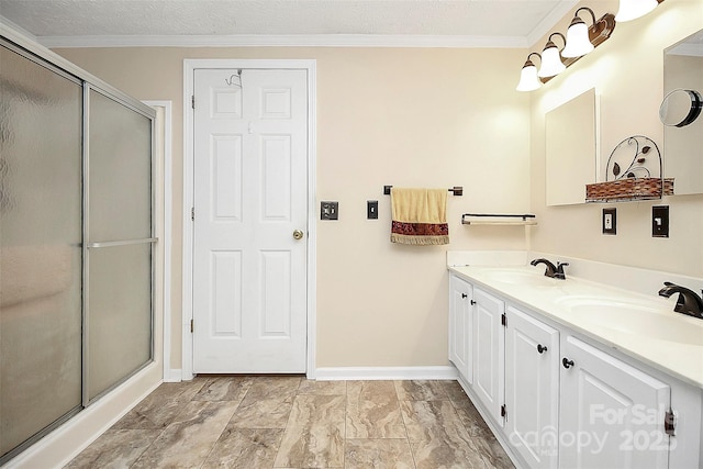 full bathroom with crown molding, a stall shower, and a sink