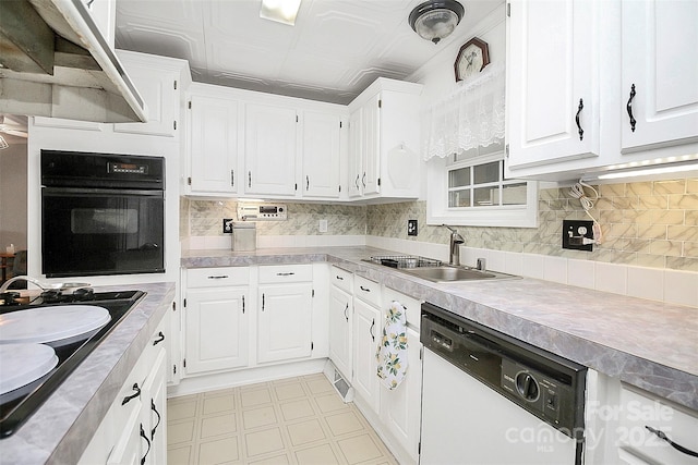 kitchen with black appliances, white cabinetry, light floors, and a sink