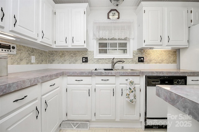 kitchen featuring dishwasher, backsplash, a sink, and white cabinetry