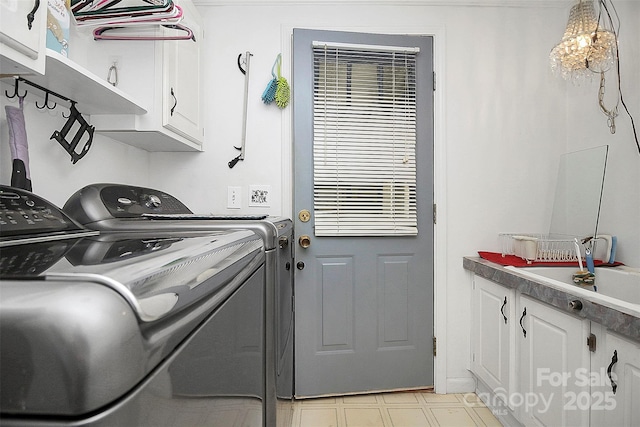 clothes washing area featuring light floors, a sink, cabinet space, and washer and dryer