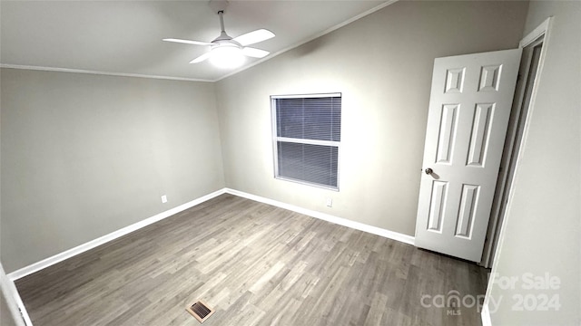 spare room with ceiling fan, ornamental molding, vaulted ceiling, and hardwood / wood-style flooring