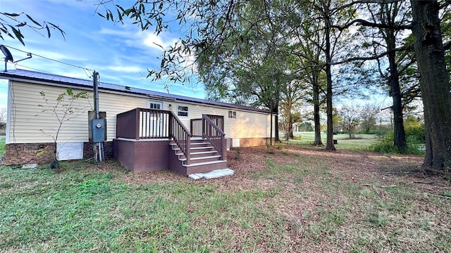 back of house featuring a wooden deck and a lawn