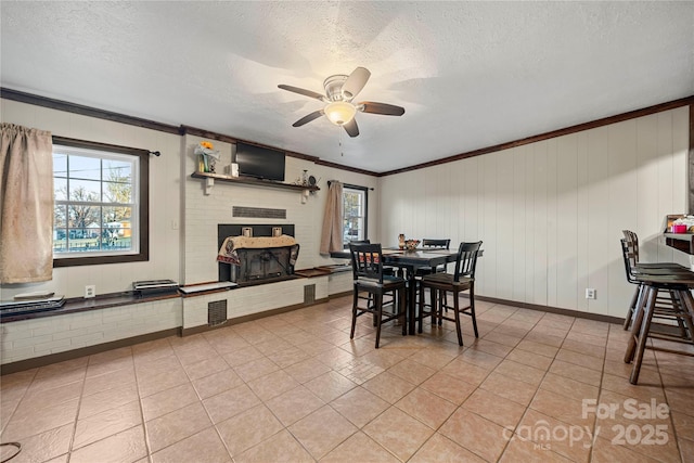 dining space featuring crown molding, ceiling fan, a healthy amount of sunlight, a textured ceiling, and light tile patterned flooring