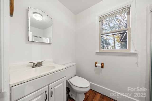 bathroom with toilet, vanity, and hardwood / wood-style floors