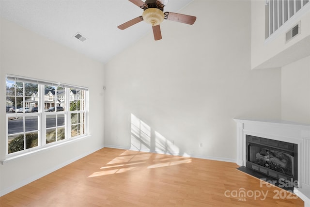 unfurnished living room with wood-type flooring, ceiling fan, and high vaulted ceiling