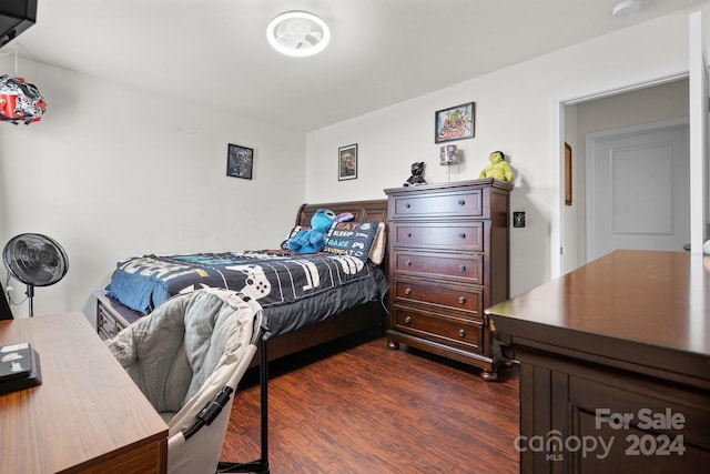 bedroom with dark hardwood / wood-style floors