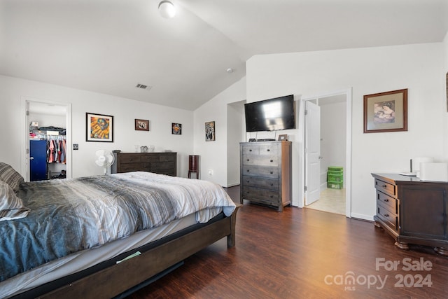 bedroom with lofted ceiling, ensuite bathroom, a spacious closet, dark hardwood / wood-style flooring, and a closet